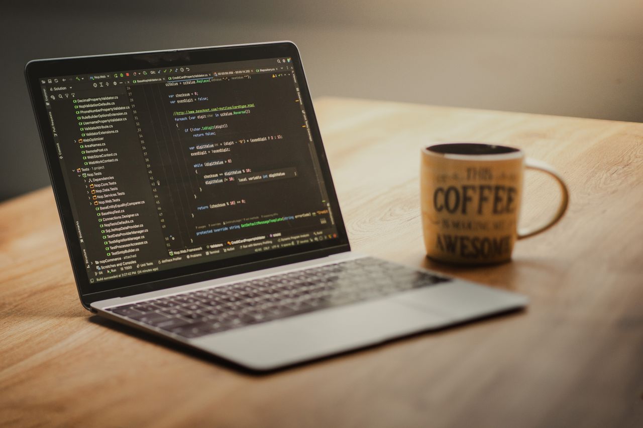 Crafting Captivating Headlines: Your awesome post title goes here Laptop displaying code editor on a desk with a coffee mug beside it, suggesting a workspace or home office setting.